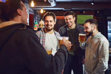 Friends talk, drink beer in a bar.