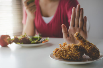 Diet. young pretty woman refuse fried chicken, junk food or unhealthy food and eating fresh green apple salad for good health at home, weight loss, healthy lifestyle, healthy food and dieting concept