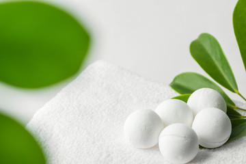 Homemade vegan bath bombs on white cotton terry towel green houseplant in bathroom. Spa wellness...