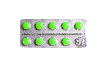 Blister pack of green pills isolated on a white background.