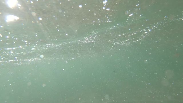 Slow motion view green color seabed floor sand waves bubble air particle
