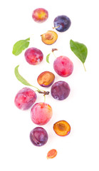 Ripe plums with leaves close up on white background