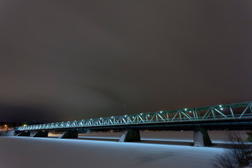 Steel road bridge over frozen river in Rovaniemi, Finland. Long exposure atmospheric.
