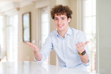 Young business man with curly read head smiling cheerful offering hands giving assistance and acceptance.