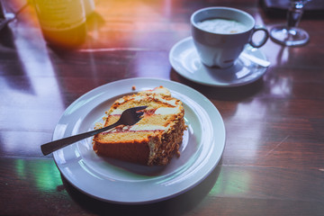 Piece of cake with coffee in a old table