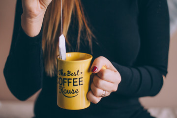 Close up of female hands with a mug and tea bag