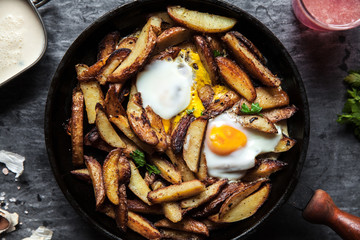 Fried potatoes and eggs in a pan close-up. horizontal