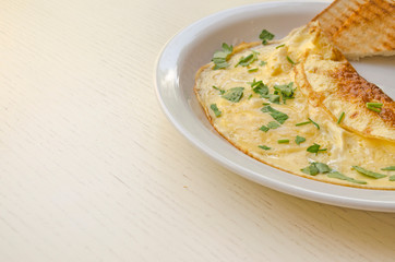 Omelet with cheese and parsley on the plate. Scrambled eggs with copy space, close up view. Healthy nutrition.