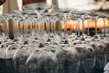 Empty clean wine glasses on counter in bar.