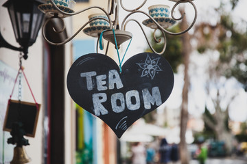 Sign of tea room chalk on a heart shape blackboard  in town