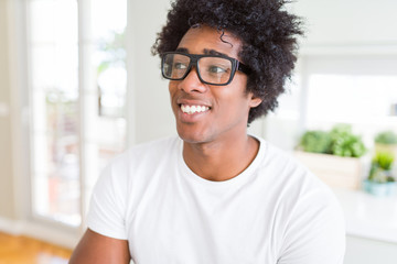African American man wearing glasses smiling looking side and staring away thinking.