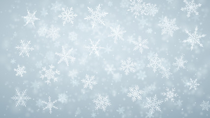 Christmas background of complex blurred and clear falling snowflakes in light blue colors with bokeh effect