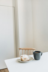 Morning breakfast with coffee and cake. Modern interior design.