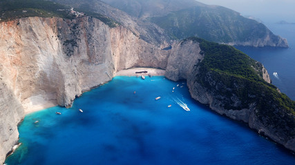 Obraz premium Aerial drone view of iconic beach of Navagio or Shipwreck voted one of the most beautiful beaches in the world with deep turquoise clear sea, Zakynthos island, Ionian, Greece