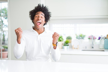 Fototapeta na wymiar African American man very happy and excited doing winner gesture with arms raised, smiling and screaming for success. Celebration concept.