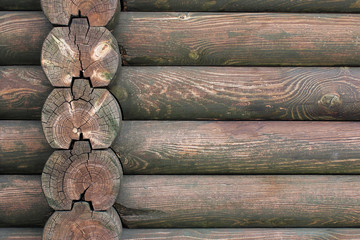 Part of wooden wall of structure build from wooden logs..