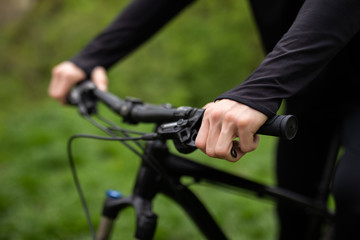 A man is riding a bicycle in a forest in the open air close-up. Park, active recreation, sports and...