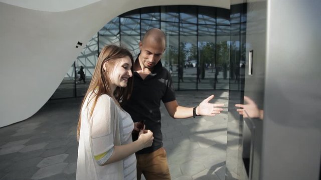 Woman and man use interactive touch screen