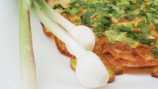 Onion pizza on white dish. National cuisine of Udmurts: The Tabani. Onion Feathers and Tortilla