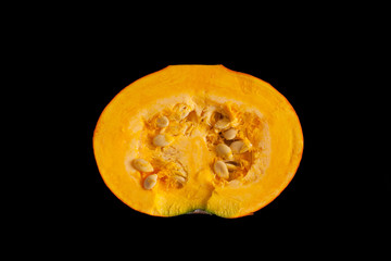 Half pumpkin with seeds isolated on black background