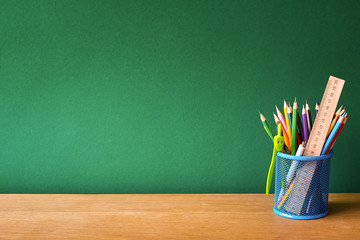 Back to school concept, blue glass with school supplies on a school desk on a background of a clean...