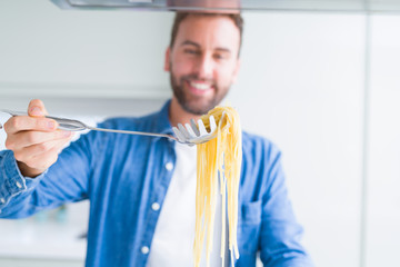 Handsome man cooking pasta at home