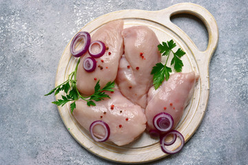 Raw organic chicken breast on a cutting board.Top view with copy space.