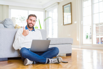 Handsome man wearing working using computer laptop happy with big smile doing ok sign, thumb up with fingers, excellent sign