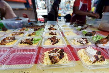 Chicken and rice in take away tubs.