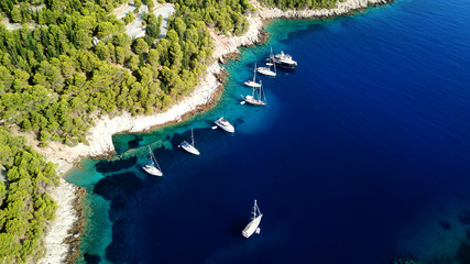 Aerial drone photo of luxury sail boats and yachts docked in turquoise clear water rocky seascape...