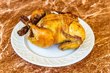 Whole Roasted Chicken on white plate and granite table top