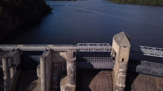 Aerial, tilt down, drone shot, over the bridge on the Solbersfossen hydropower plant dam, at Glomma river, on a sunny day, in Spydeberg, Ostfold, Norway