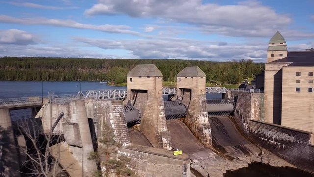 Aerial, pan, drone shot, of closed gates, at the Solbersfossen hydroelectric power station dam, at Glomma river, on a sunny day, in Spydeberg, Ostfold, Norway