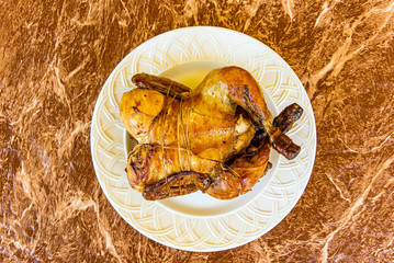 Whole Roasted Chicken on white plate and granite table top