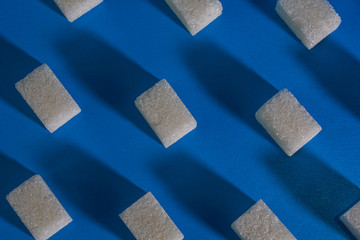 Sugar cubes on a blue background. Abstract background.