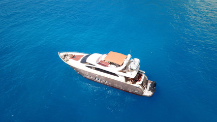 Aerial drone photo of large yacht - boat docked in tropical exotic paradise bay with emerald open ocean