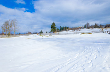 Fototapeta na wymiar winter landscape in mountain village in cloudy day