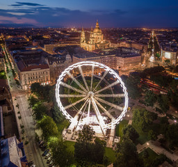 Budapest, Hungary - Aerial drone view of Elisabeth square at blue hour with illuminated ferris wheel and St. Stephen's Basilica at background. Summer evening in Budapest
