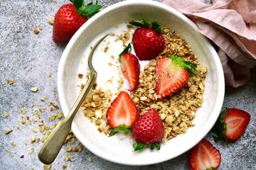 Homemade multicereal granola with yogurt and fresh strawberry for a breakfast.Top view with copy spoace.