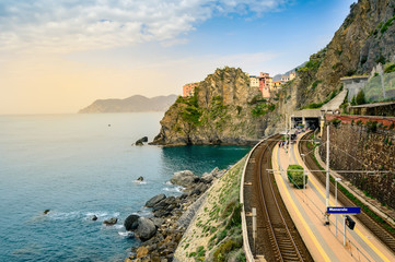 Manarola, Cinque Terre - train station in famous village with colorful houses on cliff over sea in...