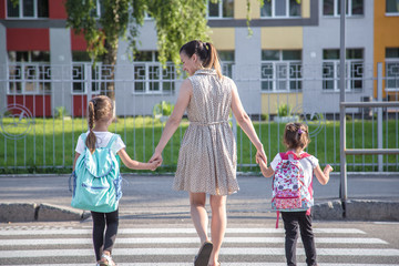 Back to school education concept with girl kids, elementary students, carrying backpacks going to class