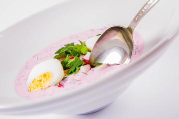 Cold borscht (chlodnik) - traditional Lithuanian cold soup with radish, parsley, dill and egg eaten with a spoon