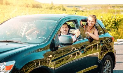 Happy young women and man driver enjoying a summer’s road trip together. Road trip Hangouts.