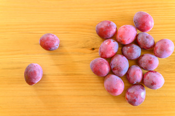 Several fresh ripe plums on wooden background