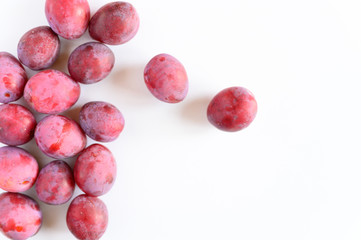 Several fresh ripe plums on white background