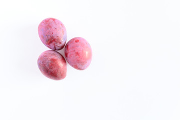 Several fresh ripe plums on white background