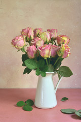 Bouquet of pink roses in a vase. Copy space background.