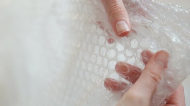 Nervous woman presses a bubble wrap to relax.