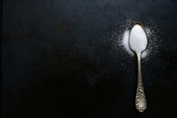 Natural white salt on a spoon. Top view with copy space.