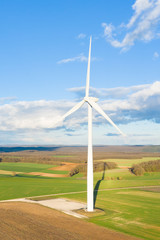 Fototapeta premium Une éolienne au milieu des champs en format portrait